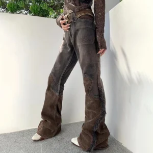 Side profile view of steampunk cowgirl flare pants showing faded denim-corduroy patchwork construction, dramatic flared leg silhouette, and distressed edges against white minimalist interior wall