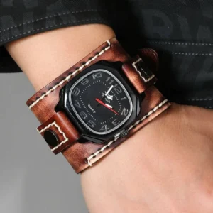 Steampunk leather cuff watch with distressed tan cowhide strap, black square dial with silver numerals and red second hand, worn on male wrist in side-front studio shot