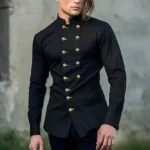 Black double-breasted steampunk stand collar shirt front view on male model, three-quarter angle showing tailored fit, brass buttons, and industrial aesthetic against concrete backdrop
