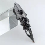 Steampunk dragon finger armor ring side view with gunblack metal finish, three black resin gems, and intricate hollow carved texture details