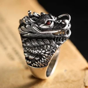 Sterling silver steampunk dragon ring front close-up displaying sharp dragon teeth, intricate scale patterns, vivid red gemstone eye detail