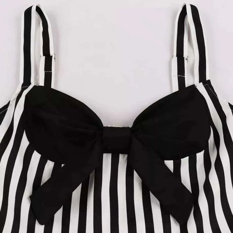 Close-up detail of steampunk dress sweetheart neckline with large black fabric bow and striped bodice construction on white background