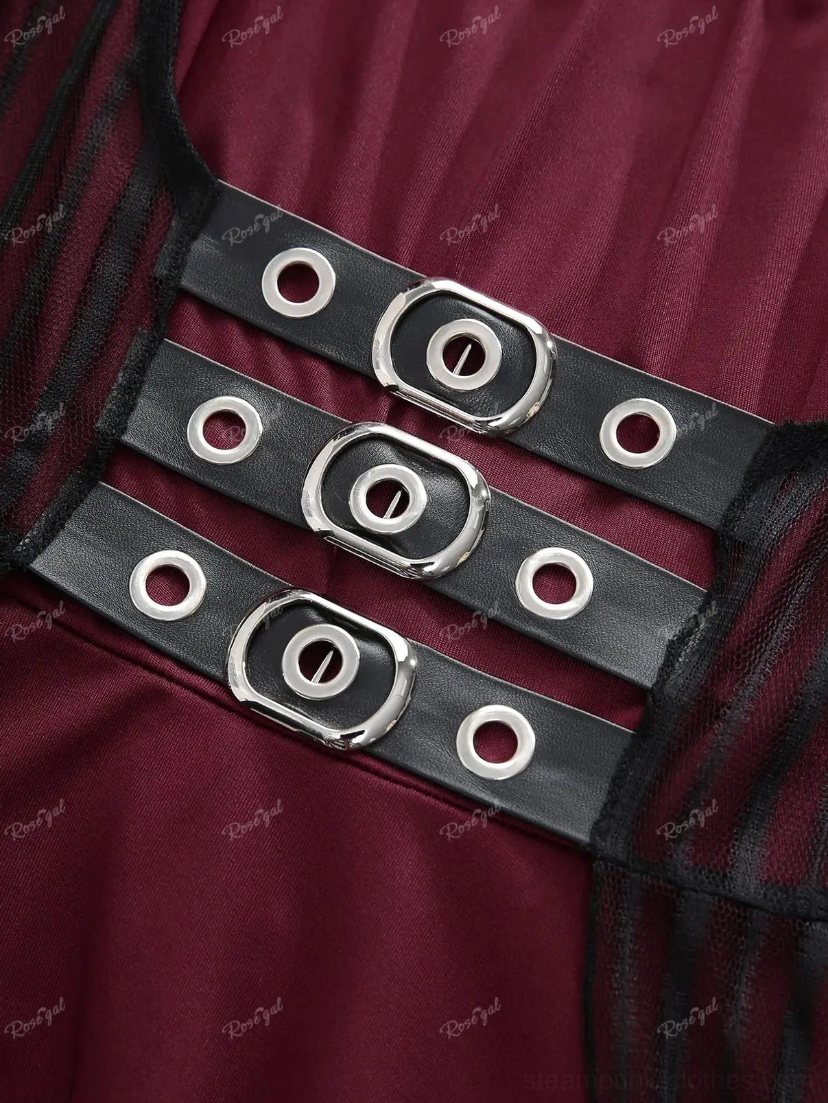 Close-up detail of steampunk dress hardware: black faux leather straps with silver metal buckles and eyelets on burgundy fabric