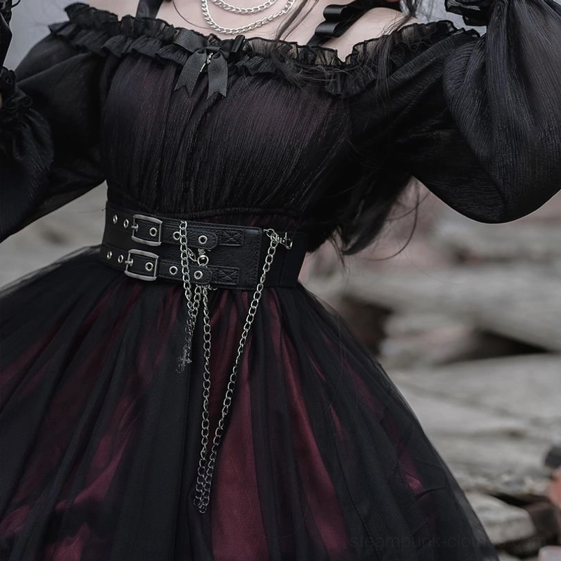 Close-up chest-level detail of gothic steampunk lolita dress showing ruffled neckline, sheer black mesh fabric, and decorative waist chain embellishment