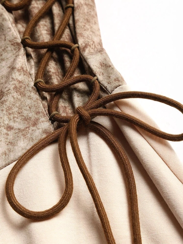 Close-up macro detail of steampunk dress showing brown rope lace-up bow, two-tone fabric texture contrast between marbled brown and beige materials, O-ring hardware
