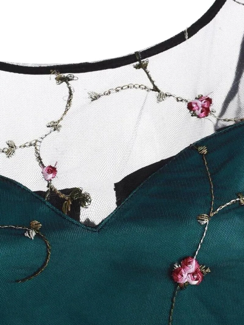 Neckline detail of steampunk dress showing black-trimmed sheer mesh sweetheart neckline with embroidered floral design