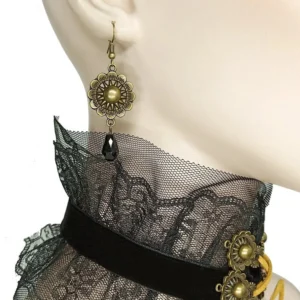 Steampunk drop earring with bronze flower frame and faux pearl, black teardrop pendant on female ear mannequin, side close-up detail shot