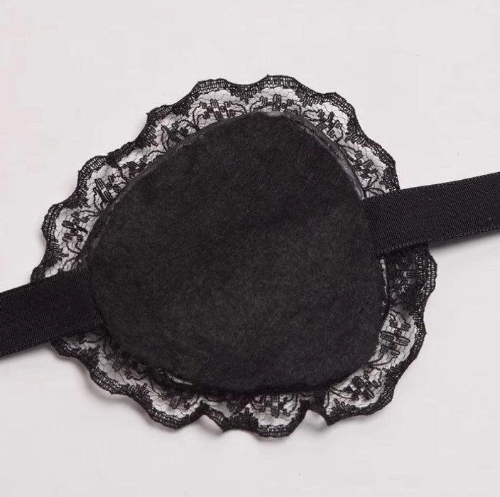 Steampunk Lolita eye patch back view displaying black lace ruffle black nylon strap and non-woven eye padding