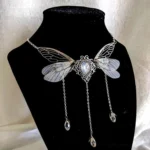 Steampunk fairy wing tassel choker necklace with translucent dragonfly wings, vintage silver frame, teardrop moonstone center, and three crystal tassel pendants displayed on black mannequin