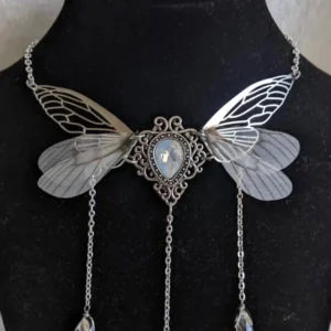 Handmade steampunk fairy wing necklace featuring cicada-style carved silver detailing, faux moonstone gem, and crystal pendants on black background