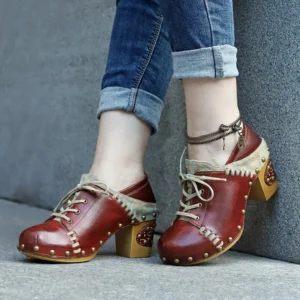 Vintage steampunk block heel boots worn with rolled denim pants and ankle bracelet, outdoor styling on concrete
