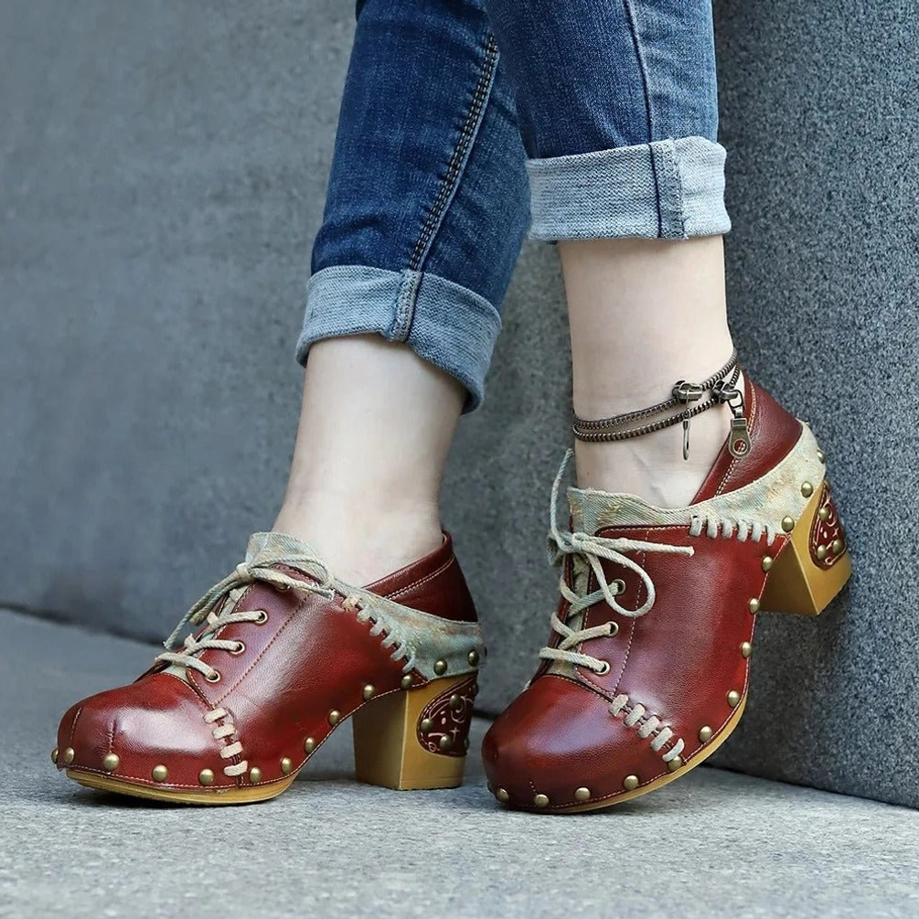 Vintage steampunk block heel boots worn with rolled denim pants and ankle bracelet, outdoor styling on concrete
