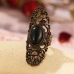 Steampunk vintage ring with Victorian filigree bronze carving and black oval gemstone, front three-quarter view
