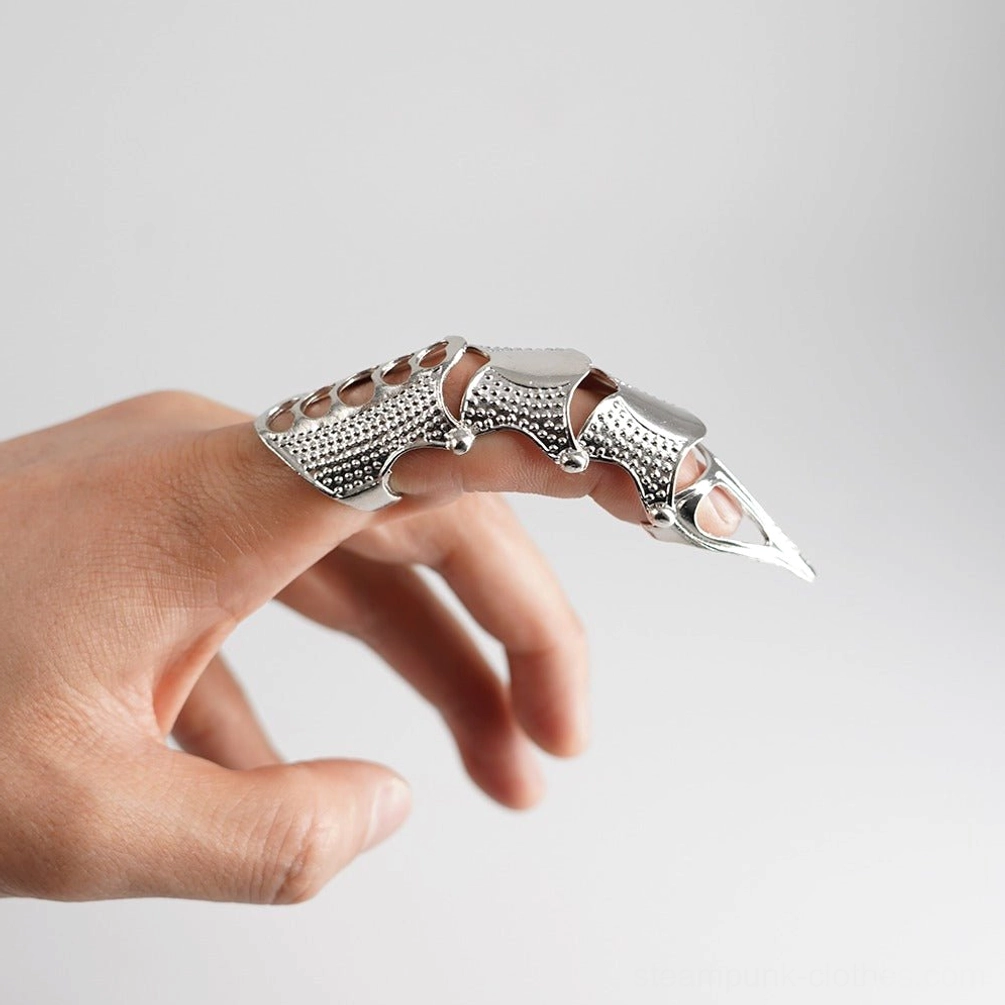 Silver steampunk finger armor ring with matte silver finish hollow joint cutouts and dotted textured surface worn on female hand