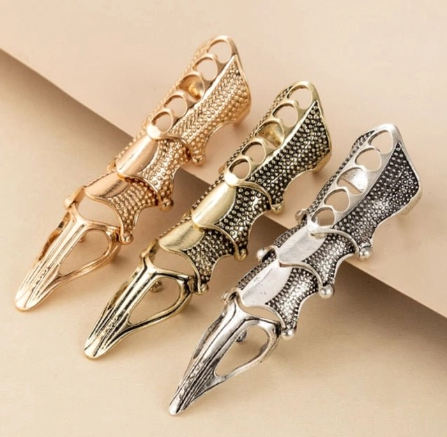 Three steampunk finger armors in rose gold antique gold and silver color options displayed flat lay showcasing the range of finish variations and mechanical design