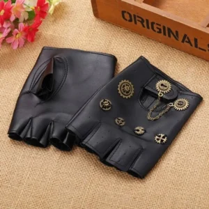 Black fingerless steampunk gloves with brass gear ornaments and metal chain pendant displayed flat on burlap surface with decorative props