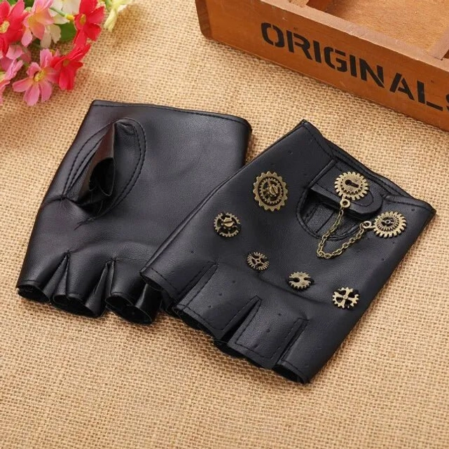 Black fingerless steampunk gloves with brass gear ornaments and metal chain pendant displayed flat on burlap surface with decorative props