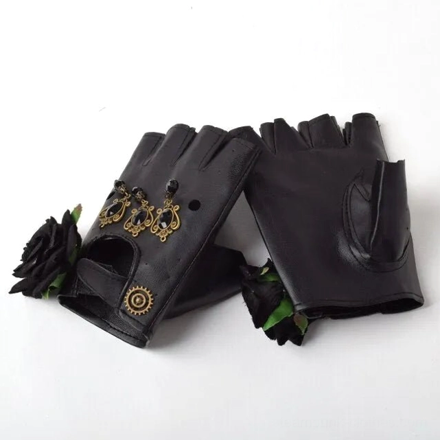 Black steampunk fingerless gloves with black fabric roses and vintage brass ornaments, flat lay on white background