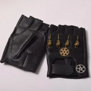 Black fingerless steampunk leather gloves with brass skull and gear ornaments, flat lay top-down view on white background