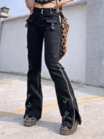 Black steampunk flared cargo trousers front view with side zippers, metal eyelets, D-rings and buckle details - female model wearing alternative gothic pants with platform boots