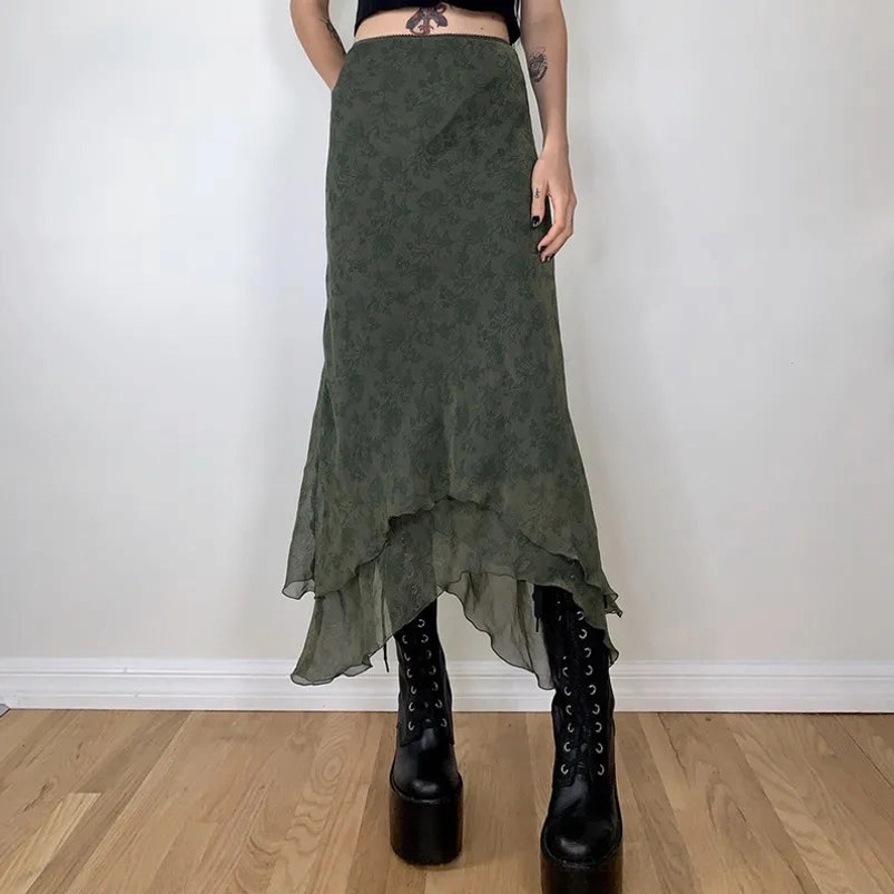 Olive green asymmetrical steampunk midi skirt with floral chiffon print worn by tattooed model in front view - high-waisted design with layered hem
