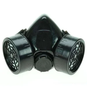 Black matte plastic dual-cartridge steampunk gas mask front view with grid-patterned filter vents and central adjustment dial on white background