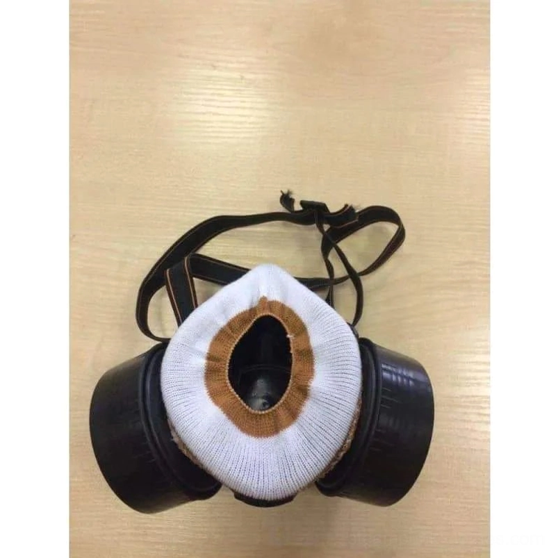 Modified steampunk gas mask flat lay showing filter canisters, fabric cuff replacement, and complete strap system detail