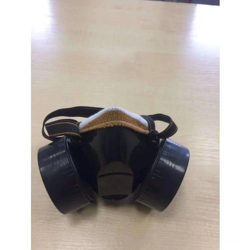 Rear view of black steampunk gas mask showing back assembly, fabric strap harness, and mechanical attachment points