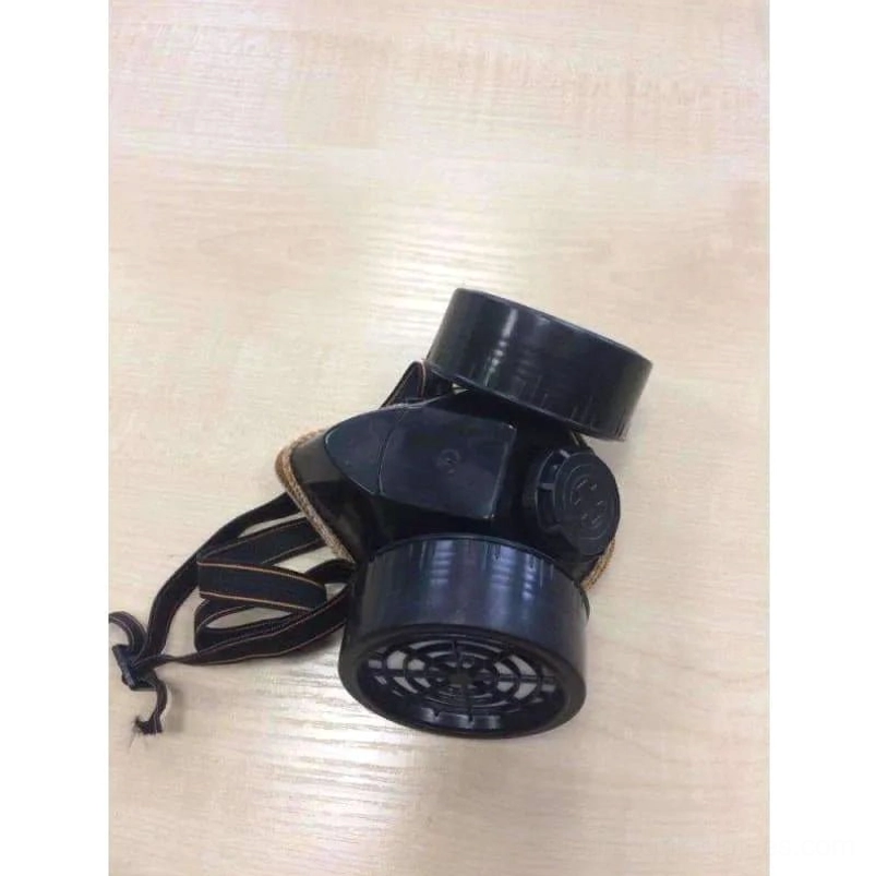 Steampunk gas mask top-down side angle showing adjustable fabric head straps with tan accent reinforcement and dual-filter configuration