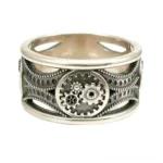 Adjustable steampunk gear band ring in aged silver stainless steel with intricate hollow-carved design and central gear cluster detail, front three-quarter view showcasing mechanical craftsmanship