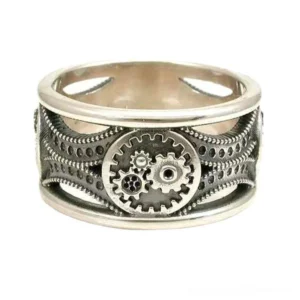 Adjustable steampunk gear band ring in aged silver stainless steel with intricate hollow-carved design and central gear cluster detail, front three-quarter view showcasing mechanical craftsmanship