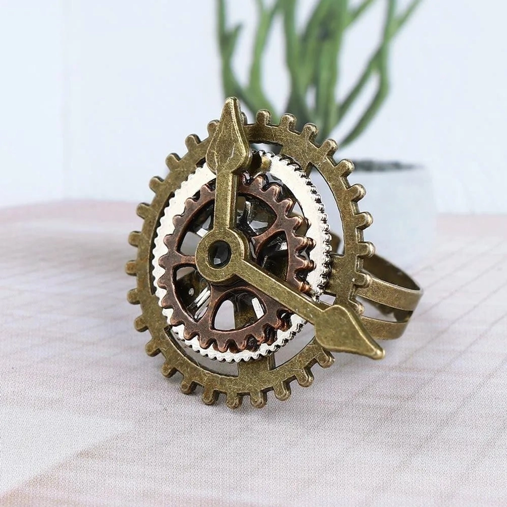 Steampunk gear clock ring front view showcasing multi-layer interlocking bronze metal gears with clock pointer design on checkered fabric backdrop