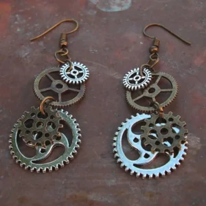 Steampunk gear dangle earrings featuring layered bronze and silver metal gears on rusty dark brown backdrop, showcasing intricate mechanical design from overhead flat view