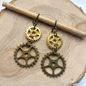 Steampunk dual gear drop earrings flat lay on wooden backdrop, showing antique bronze and gold stacked gear design from top-down perspective