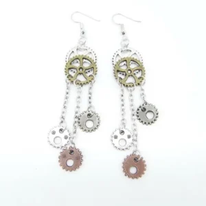 Symmetrical steampunk gear earring pair displayed in flat lay, showing complete chain tassel and gear charm details from frontal view