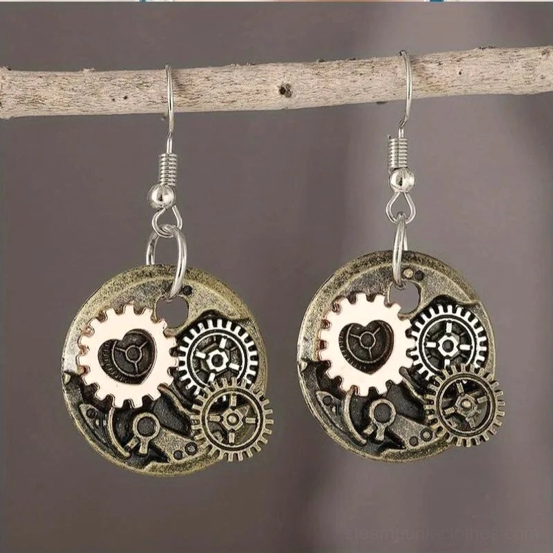 Steampunk gear heart drop earrings with vintage mixed metal finish and rose-gold accents, hung on wooden branch against dark background
