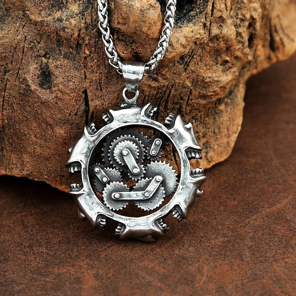 Steampunk gear pendant necklace displayed on brown leather with rustic wood block, three-quarter side angle view showcasing antique silver finish and intricate gear set design