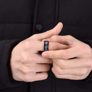Men wearing steampunk gear ring on index finger, showing industrial cog pattern and multi-tone blue bronze detail, worn with black coat
