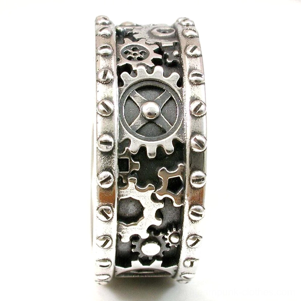 Steampunk gear ring vertical side close-up detail showing intricate carved gear patterns, rivet-studded edge, worn vintage metal texture, and dimensional depth of carving