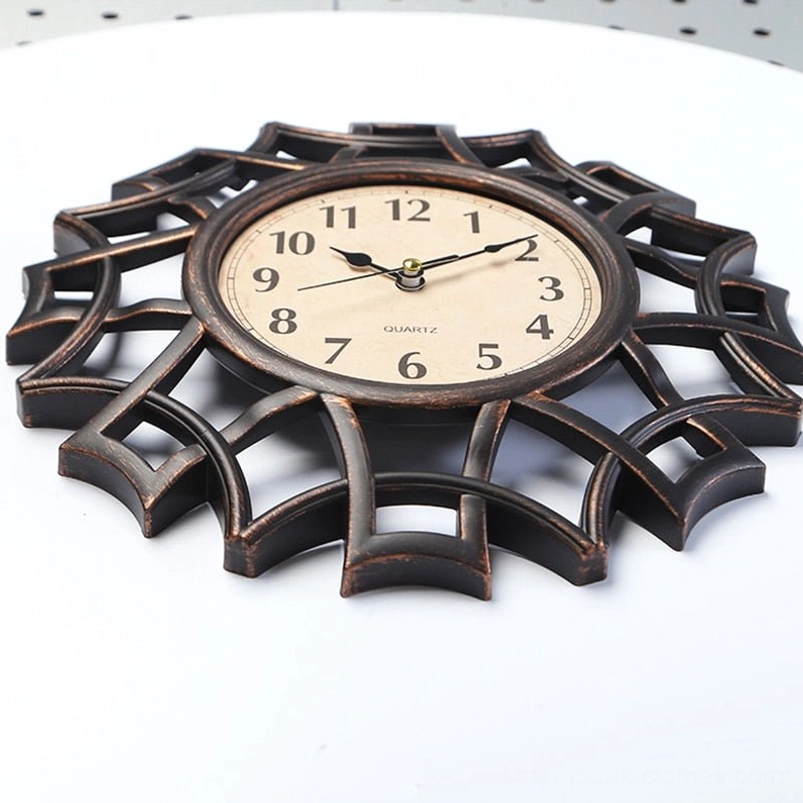 Overhead side view of steampunk geometric wall clock showing black-bronze frame 3D hollowed web outline and dimensional depth on white surface