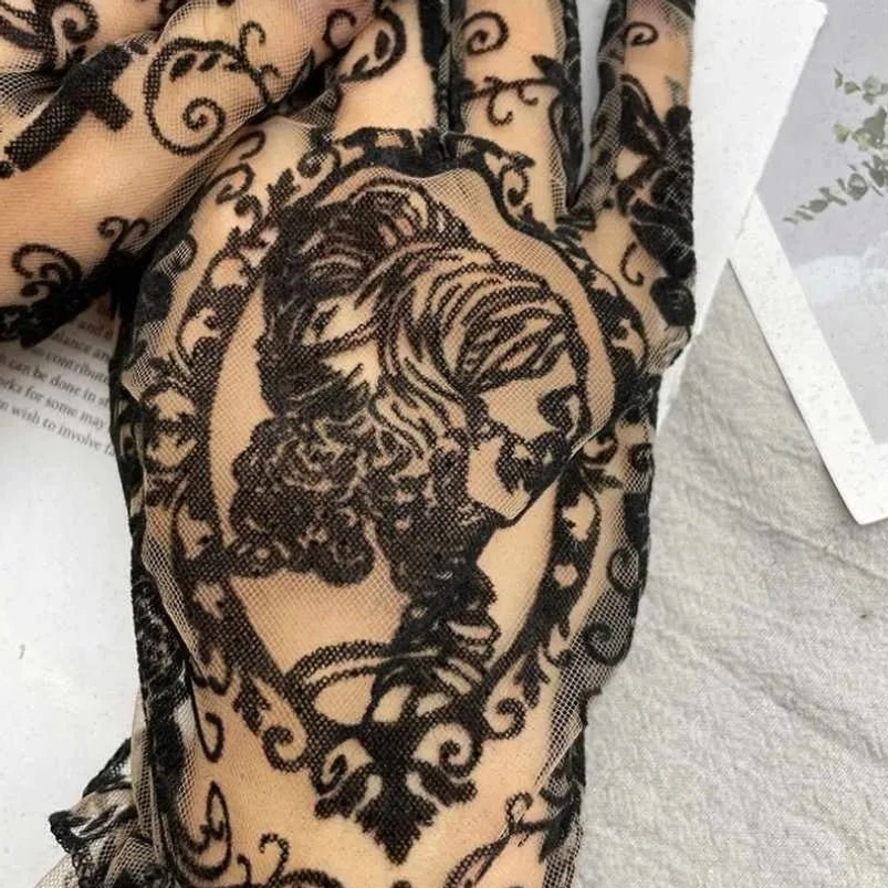 Side view close-up of gothic lace steampunk glove featuring vintage cameo lady pattern, ornate lace trim detail, and sheer mesh base construction
