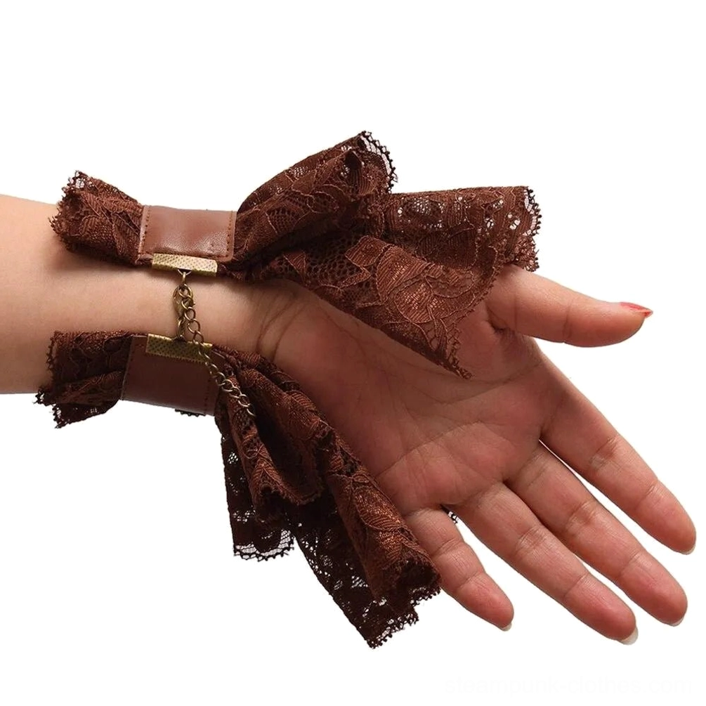 Close-up detail of steampunk lace wrist cuff with brown faux leather strap, hanging metal chain, and ruffled lace trim, side view