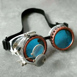 Handmade steampunk goggles with copper rim and blue polycarbonate lenses featuring magnifying loupes attachment, three-quarter overhead view