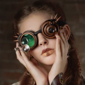 Green lens steampunk goggles with spiked metal frame and side magnifier worn by model with braided hair