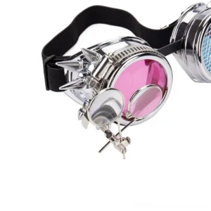 Close-up detail of steampunk goggles showing secondary magnifying lens, blue and pink optics, metal spike decorations, and frame structure