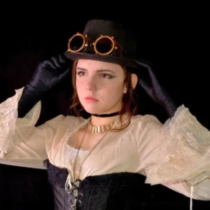 Woman wearing steampunk aviator goggles on black top hat with Victorian corset and lace blouse - styled cosplay portrait