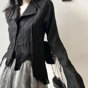 Black asymmetric steampunk blouse with crinkled texture and exposed midriff, styled with chain crossbody accessory and uneven hemline - three-quarter side view