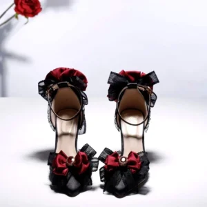 Black steampunk gothic high heel shoe front view featuring pointed upper, wine-red flower ornaments, delicate lace trim, and stiletto heel - straight frontal angle