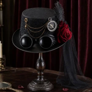 Black steampunk gothic top hat with lace detailing, compass, gold chains, red rose, studded goggles, feather and veil - front three-quarter view on vintage wooden display stand