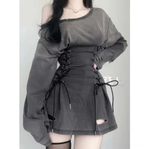 Off-shoulder lace-up steampunk grunge mini dress in washed grey, front view on model with long dark hair, featuring oversized sleeves and side corset lacing against plain wall background